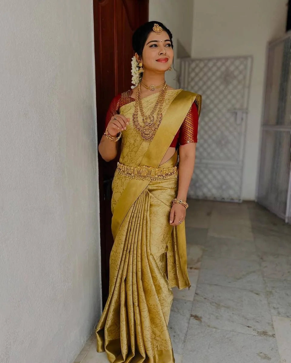 Woman in a traditional yellow saree with red blouse indoors.
