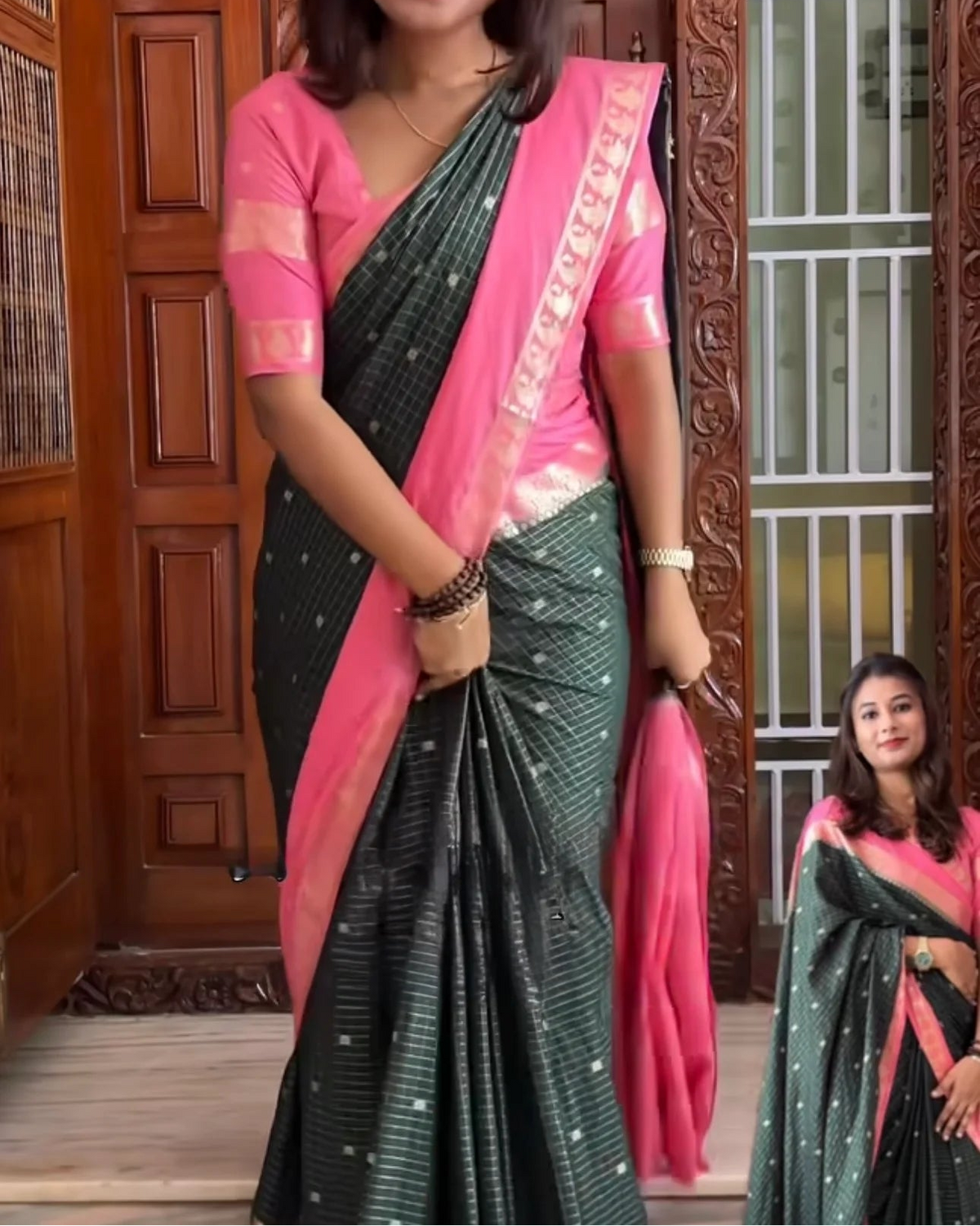A woman modeling a Mysore crepe silk zip & go saree, featuring a dark green body with fine white stripes, a vibrant pink border, and a solid pink blouse with gold embroidery.