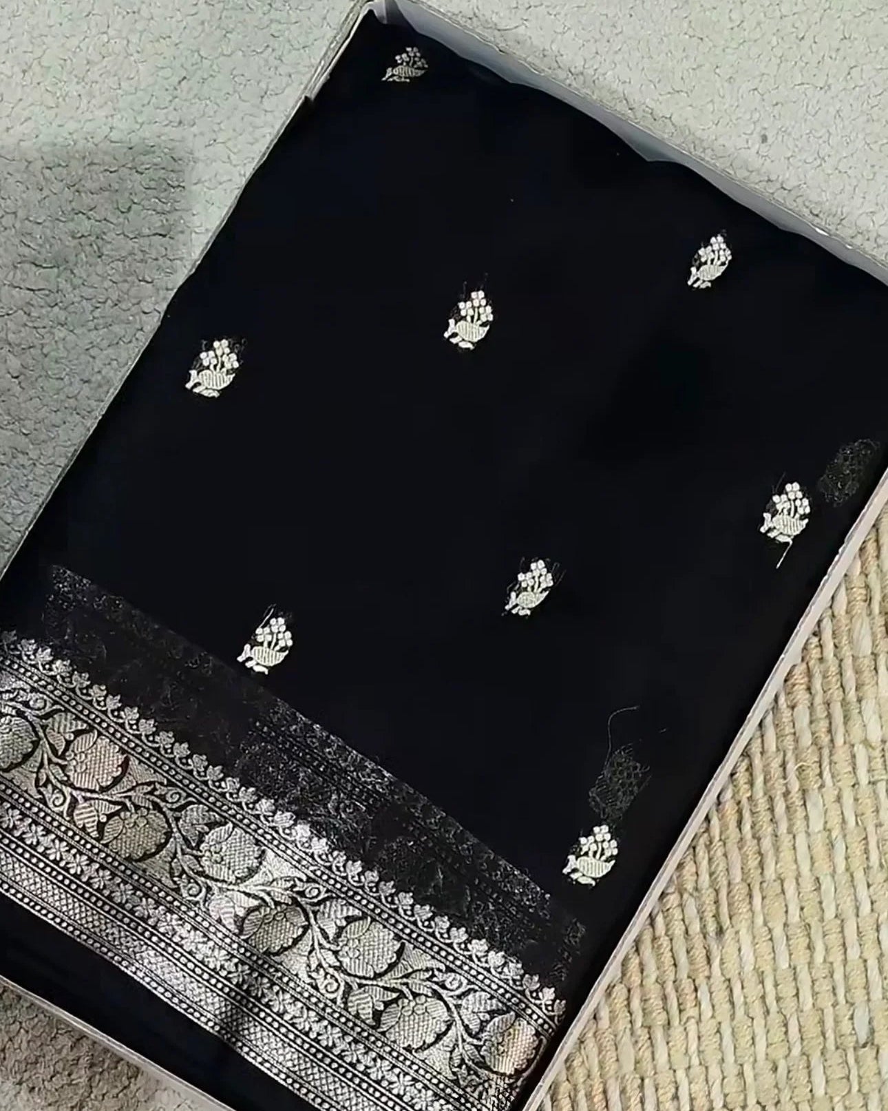 Black fabric with white floral patterns on a textured surface