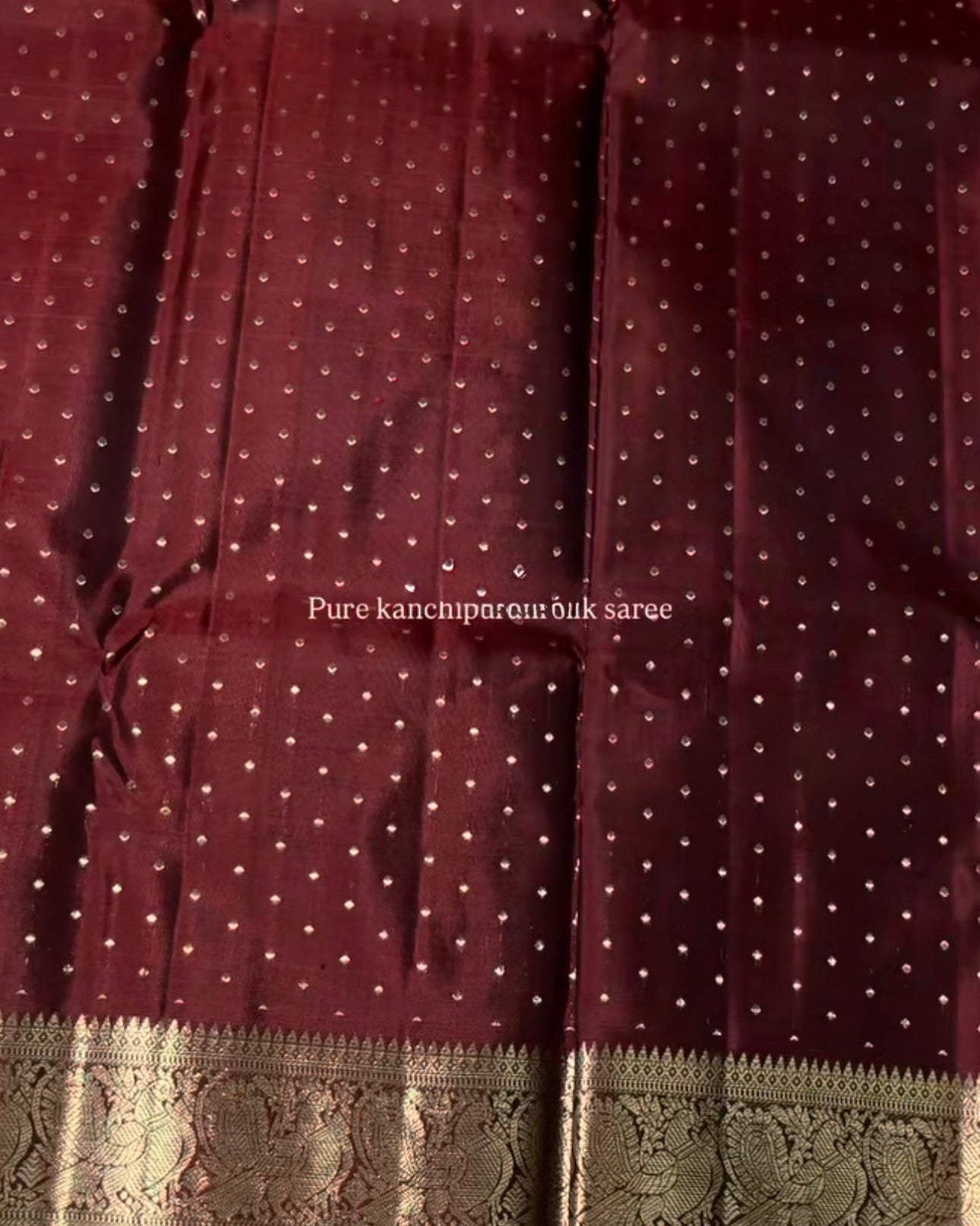 Maroon saree with white polka dots and a green border