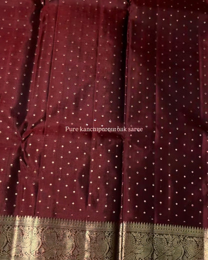Maroon saree with white polka dots and a green border