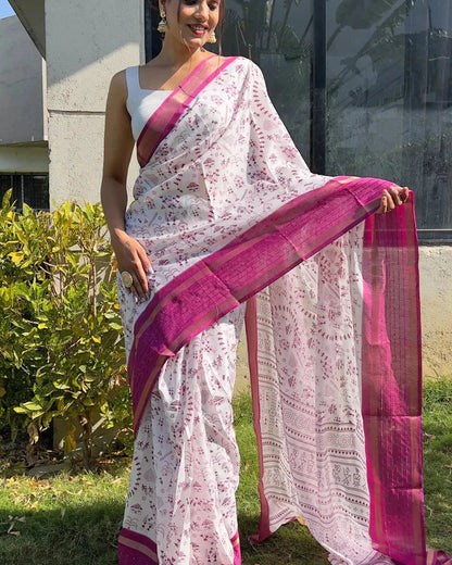 Woman wearing a white saree with pink border outdoors