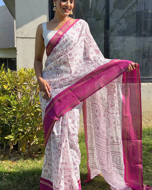 Woman wearing a white saree with pink border outdoors