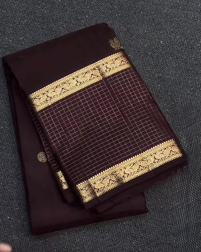 Brown fabric with gold lace trim on a textured surface