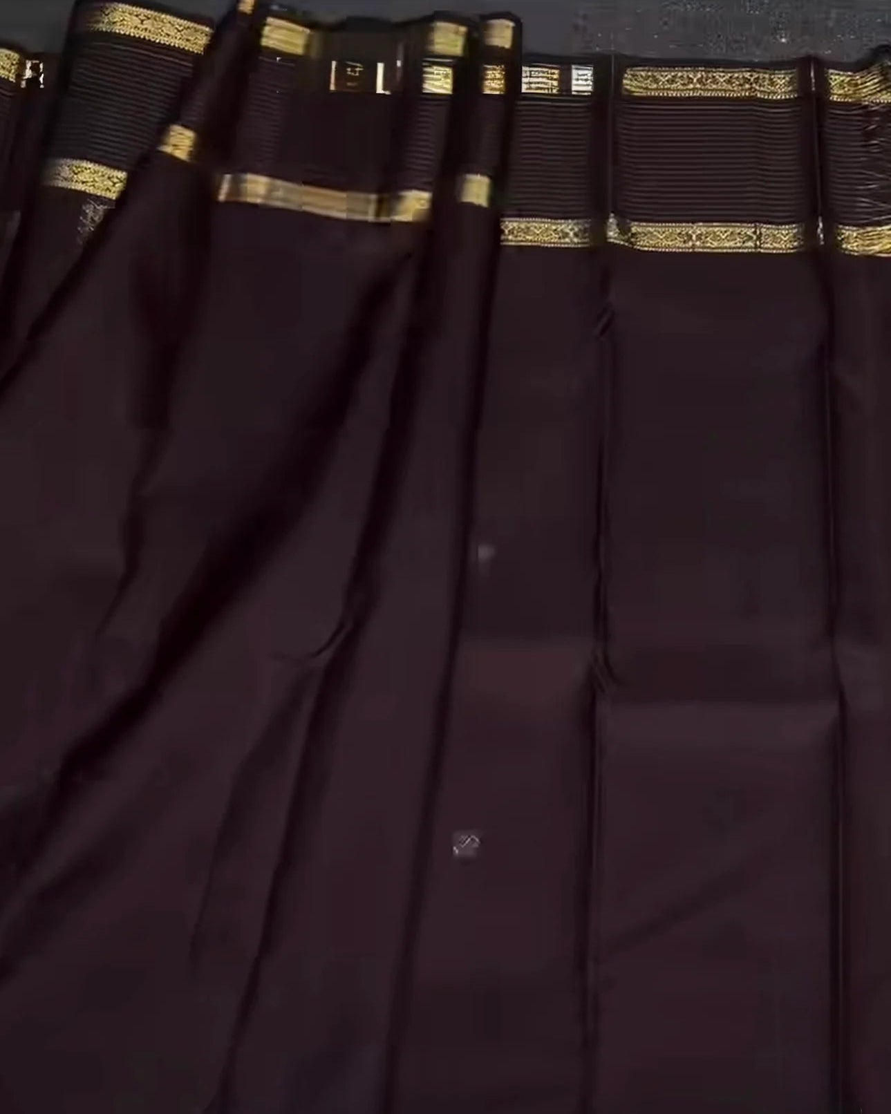 Dark purple fabric with gold border and pattern