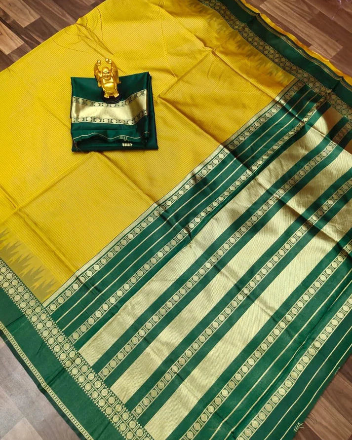 Yellow and green saree with a decorative item on a wooden floor