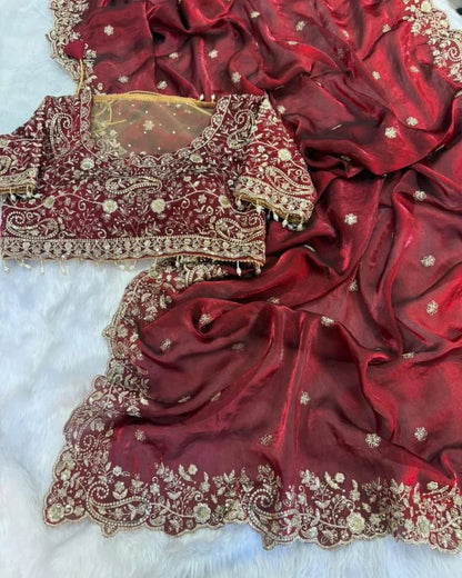 Red saree with gold embroidery on a white background