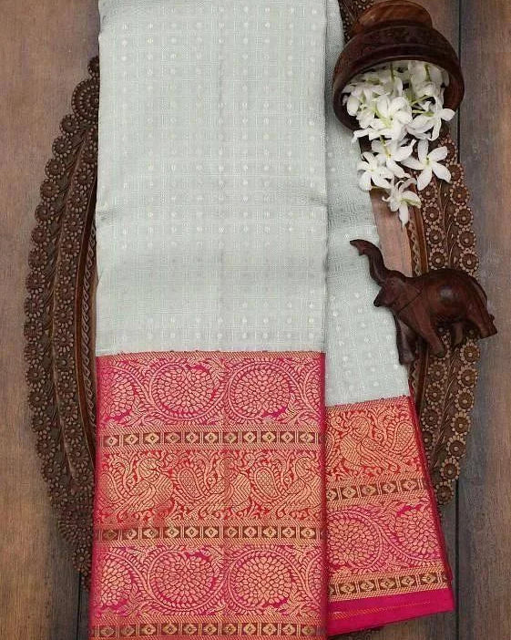 White saree with pink border on a wooden background