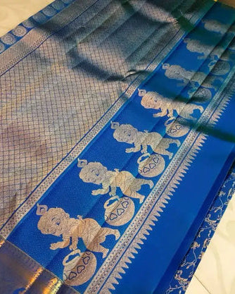 Blue saree with gold and white patterns on a neutral background