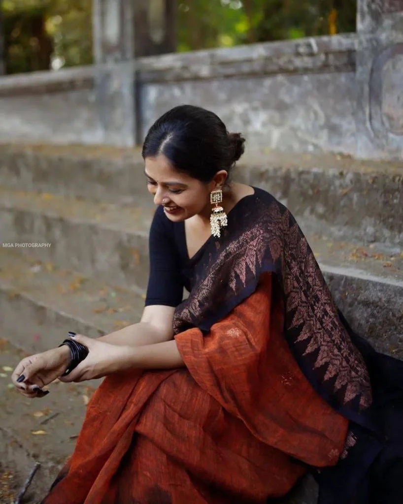 Woman in a traditional saree sitting on steps outdoors
