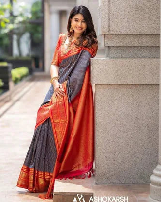Woman in a traditional saree standing against a stone wall with 'ASHOKARSH' branding.