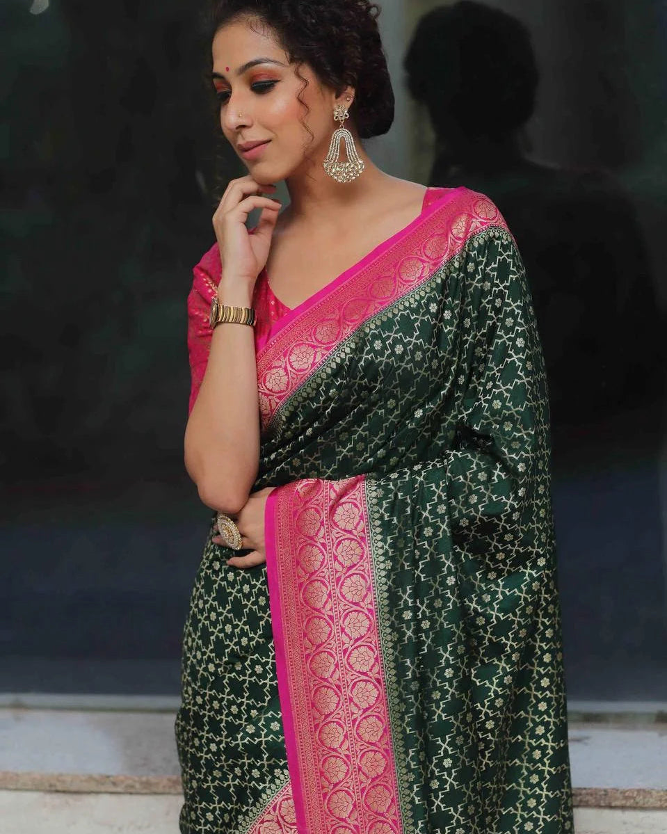 Woman wearing a green and pink saree with intricate patterns.