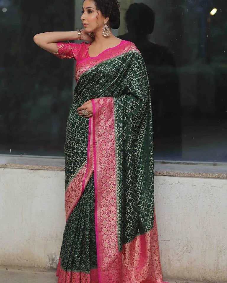 Woman wearing a green and pink saree with a reflective surface in the background