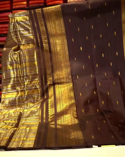 Folded fabric with gold and black patterns on a wooden surface.