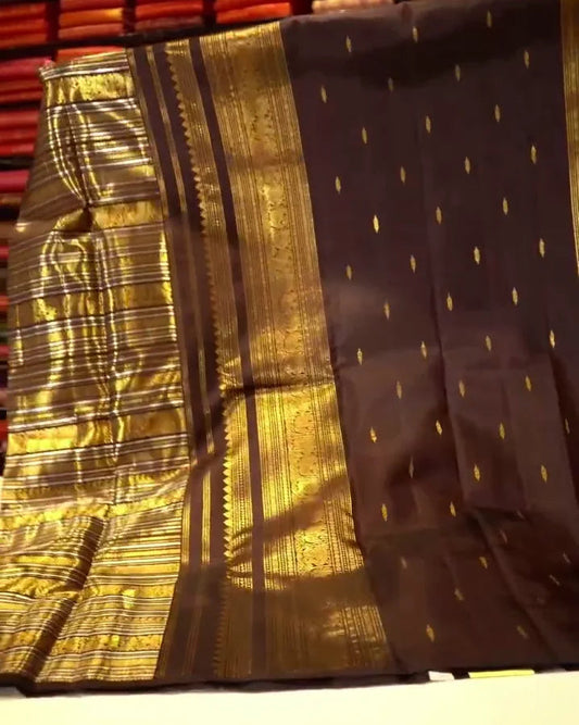 Folded fabric with gold and black patterns on a wooden surface.